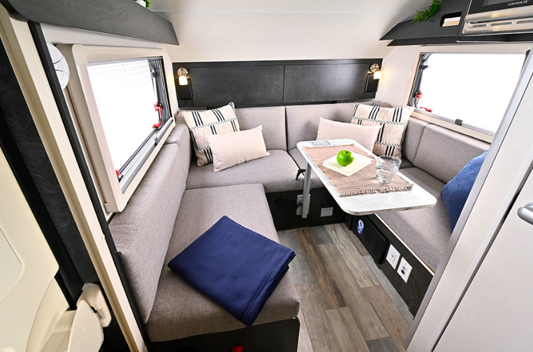 Interior of a nuCamp TAB 320S teardrop camper with neutral decor in the living area.