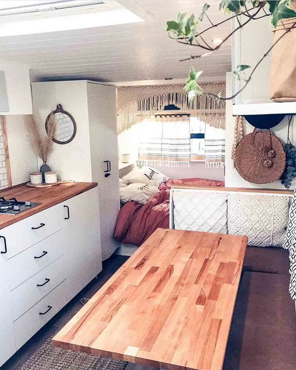 Interior of a renovated travel trailer showing the dining area and kitchen